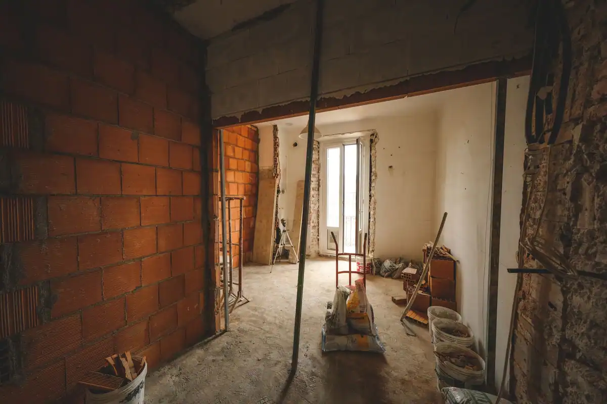 Cameră parțial renovată, cu cărămidă la vedere și materiale de construcție
