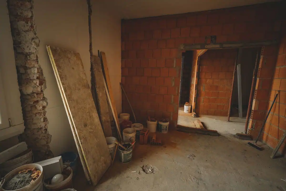 Perete de cărămidă în lucru, cu unelte și materiale de construcție