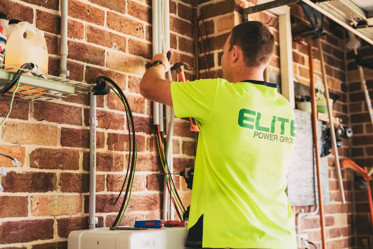 Electrician care montează o baterie de stocare a energiei într-o locuință