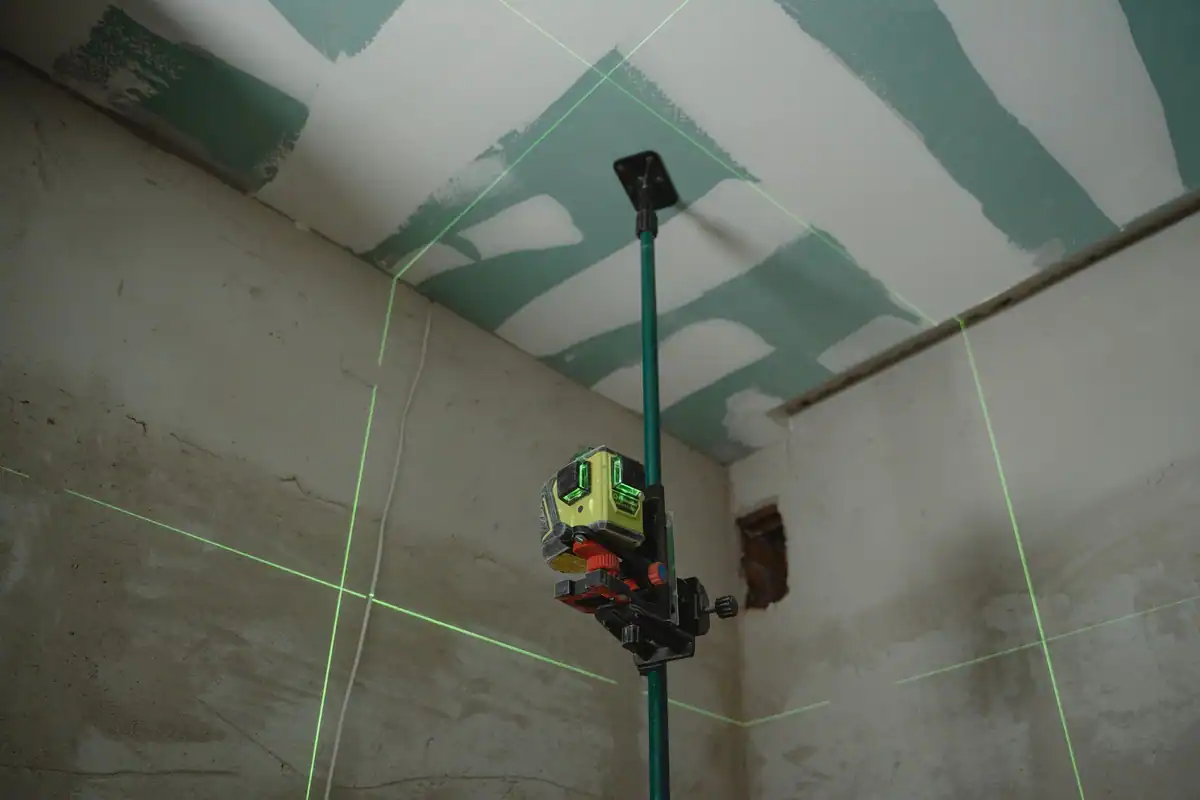 Nivelă laser care proiectează linii pe pereții unui șantier interior