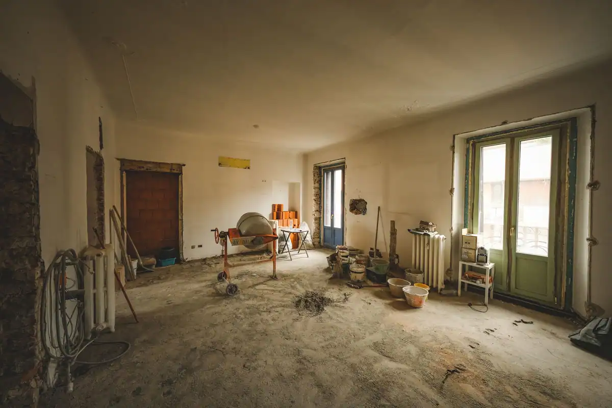 Cameră însorită în renovare, cu materiale și unelte pe jos