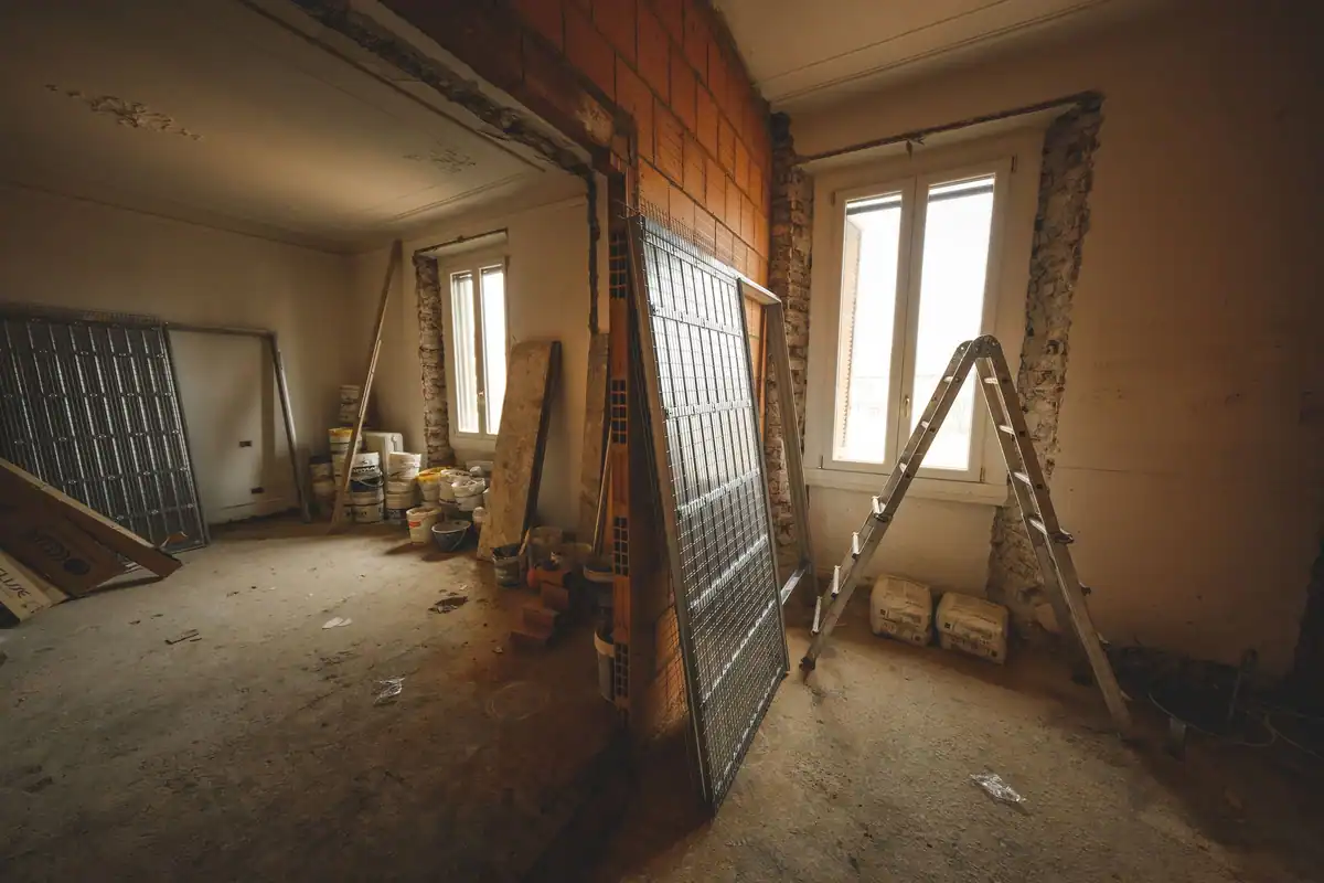 Încăpere în renovare cu materiale de construcție și o scară