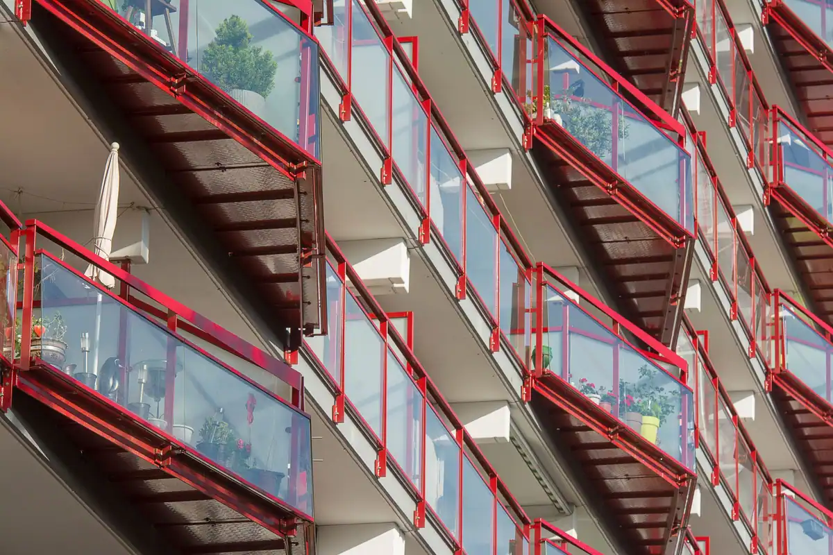 Balcoane moderne de bloc cu balustrade roșii și panouri de sticlă