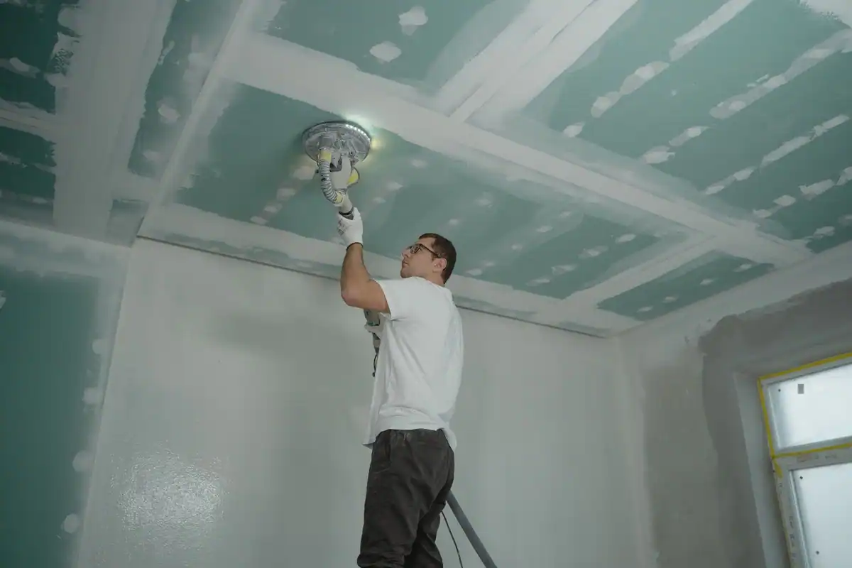 Muncitor care finisează un tavan în interiorul unei locuințe