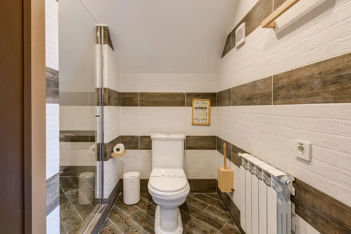 Baie minimalistă, cu gresie albă curată și obiecte sanitare moderne